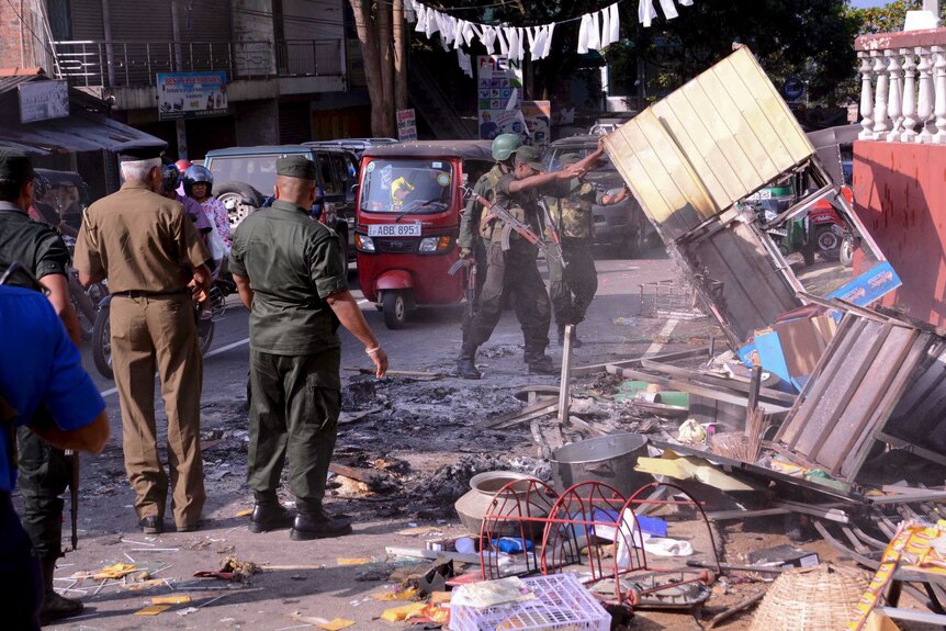 Sri Lanka's army soldiers remove the debris from a vandalized building