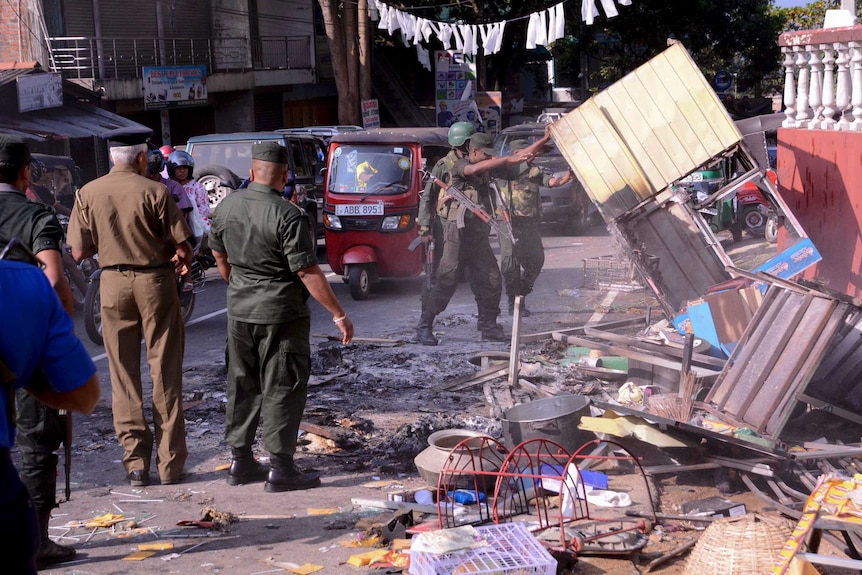 Tentara Sri Lanka menyingkirkan puing dari bangunan yang dirusak.