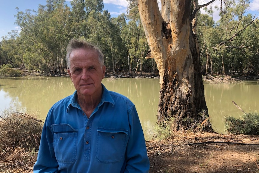 Man stands by on the banks of the Darling River