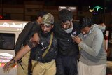 A Pakistani volunteer and a police officer rush an injured person to a hospital in Quetta, Pakistan, Monday, Oct. 24, 2016