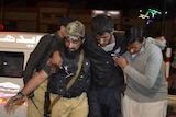 A Pakistani volunteer and a police officer rush an injured person to a hospital in Quetta, Pakistan, Monday, Oct. 24, 2016