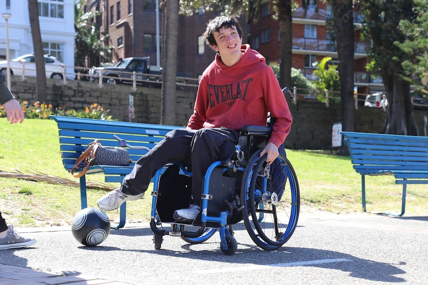 A man in a wheelchair smiles for the camera