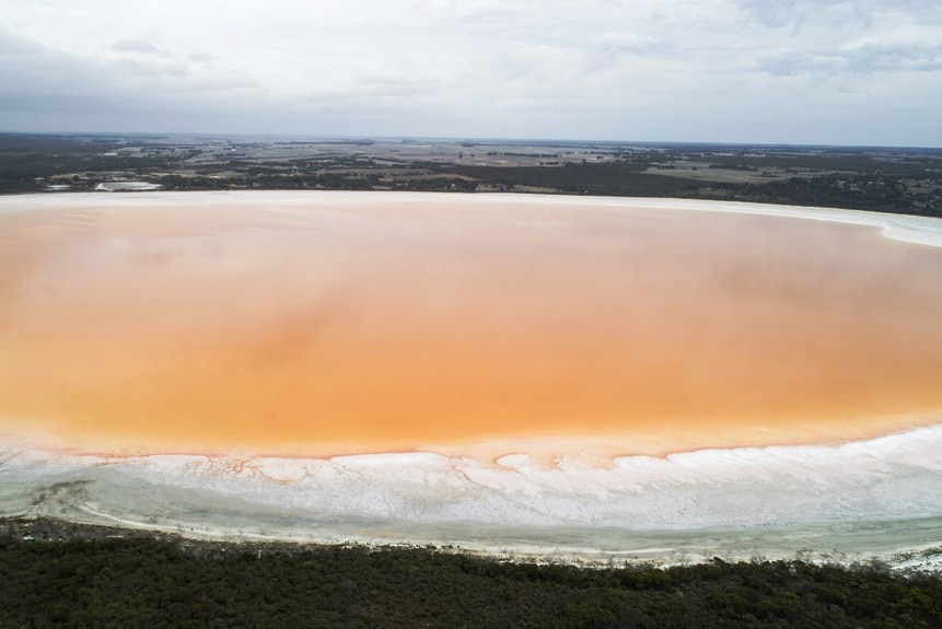 An aerial photograph of a rust-coloured lake