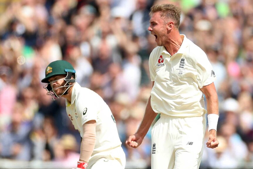 Stuart Broad shouts as David Warner adjusts his pad on the pitch during a Test match.