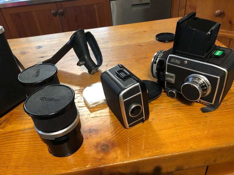 A camera and lenses laid out on a wooden table