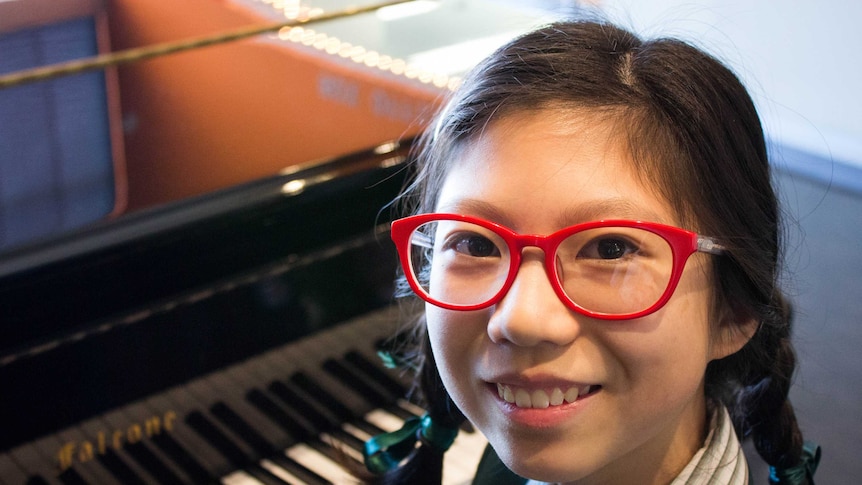 A close up of 12-year-old Irene Li in front of her piano