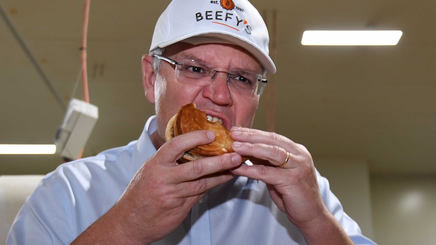 Prime Minister Scott Morrison eats a pie during a visit to the Beefy's Pies factory.