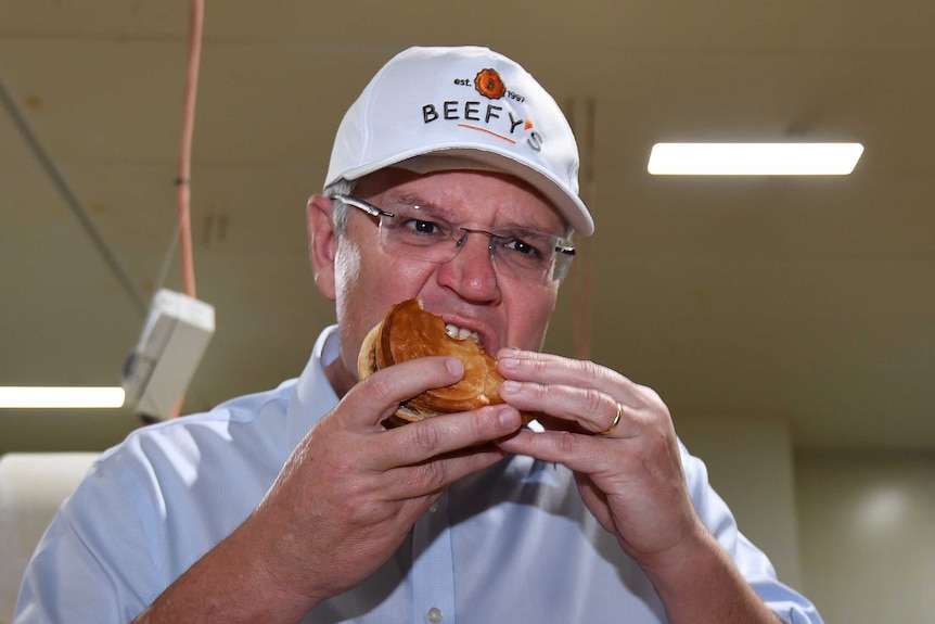 Prime Minister Scott Morrison eats a pie during a visit to the Beefy's Pies factory.