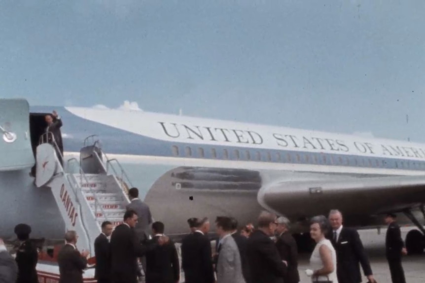 A blue plane with the words "United State of America" on the side with Qantas steps leading up to the door.