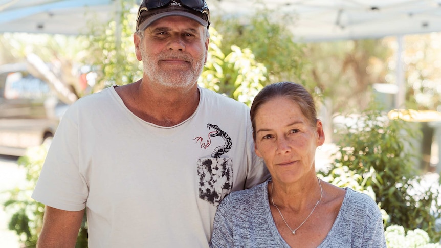 Gary and Karen smile with their arms around each other.