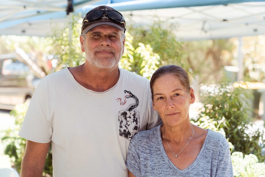 Gary and Karen smile with their arms around each other.