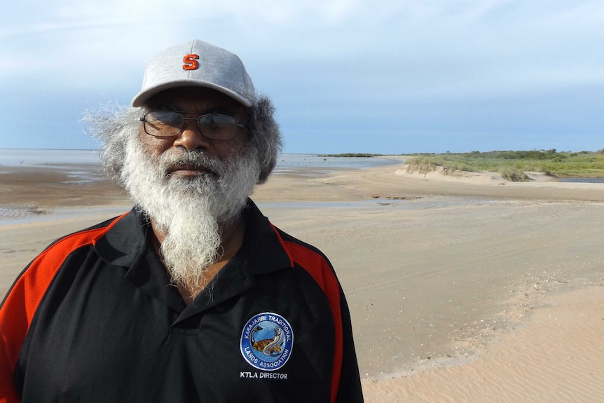 Aboriginal man standing at sunset at a beach