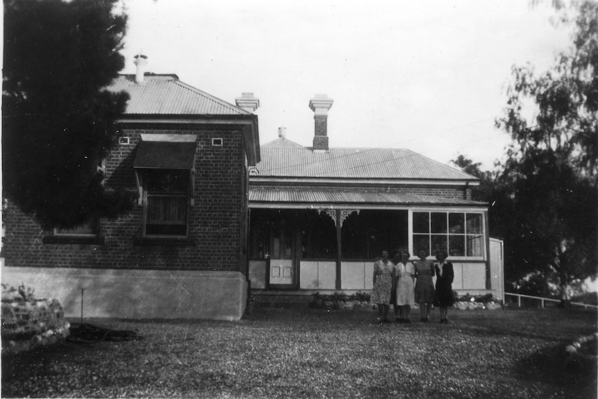 A black and white photo of Cootamundra Domestic Training Home for Aboriginal Girls with people standing out the front