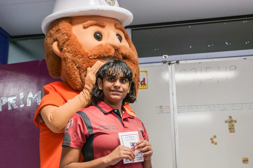 Miner Mick gives a certificate to Mount Isa Special School student Darcey