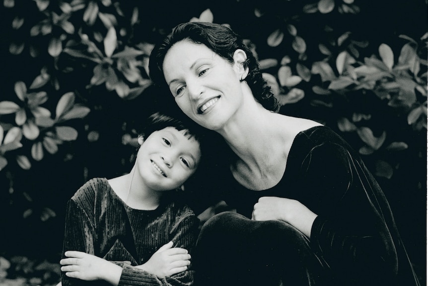 A black and white image of a mother and her daughter, both in ballet tights