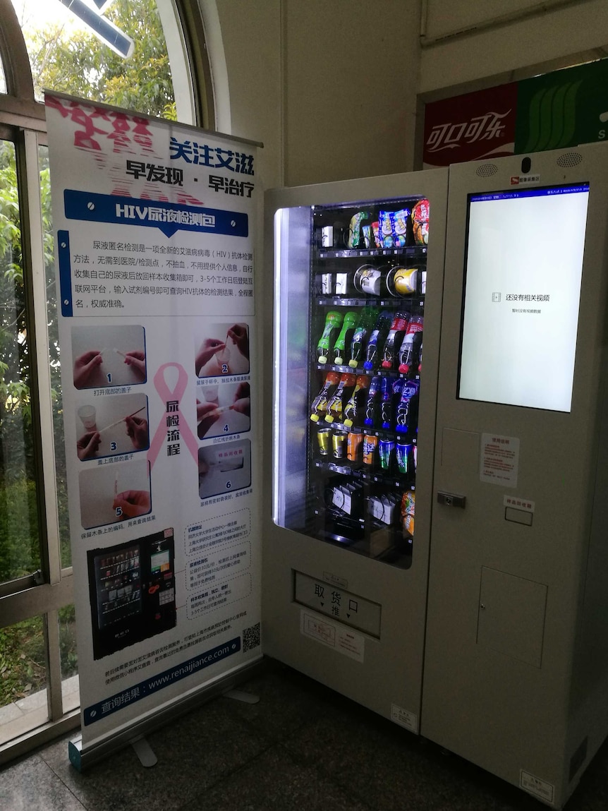 Vending machine in Shanghai Lixin University of Accounting and Finance next to a banner explaining how the HIV tests worked.