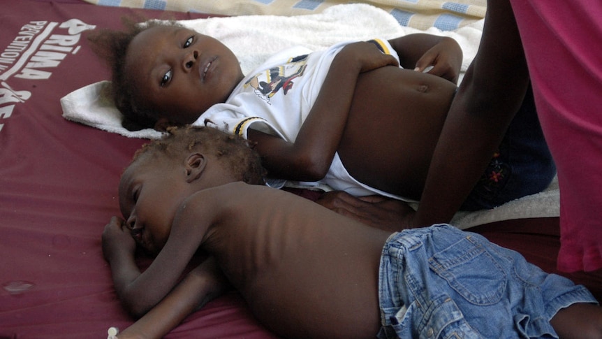 Children suffering from cholera wait for medical treatment at a local hospital