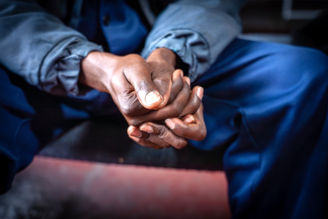 A man's hands, clasped together, seen from close up.