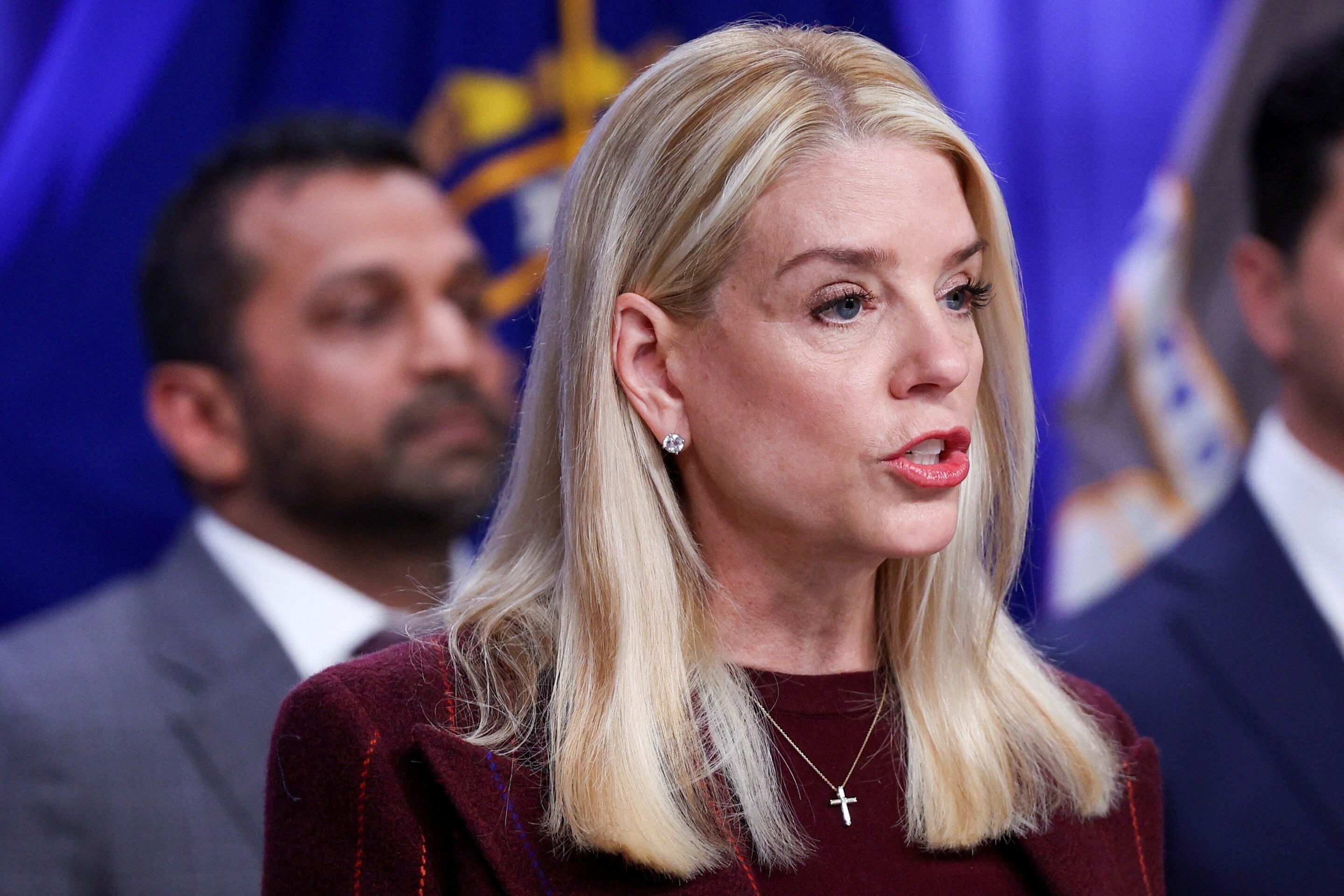 A woman with smooth, blonde hair speaks with raised eyebrows