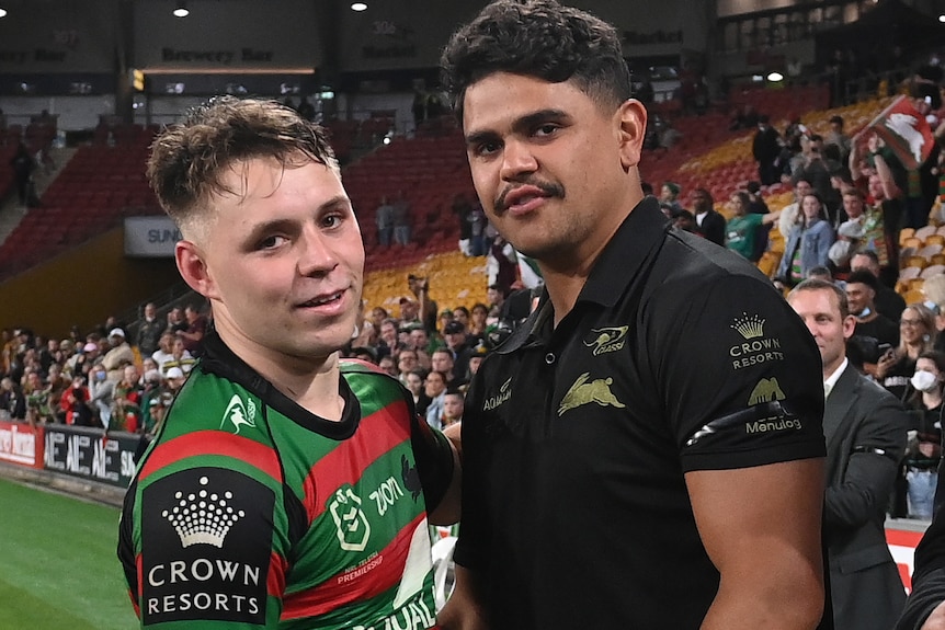 South Sydney Rabbitohs' Blake Taaffe stands on the sidelines with teammate Latrell Mitchell, who is not in his jersey.