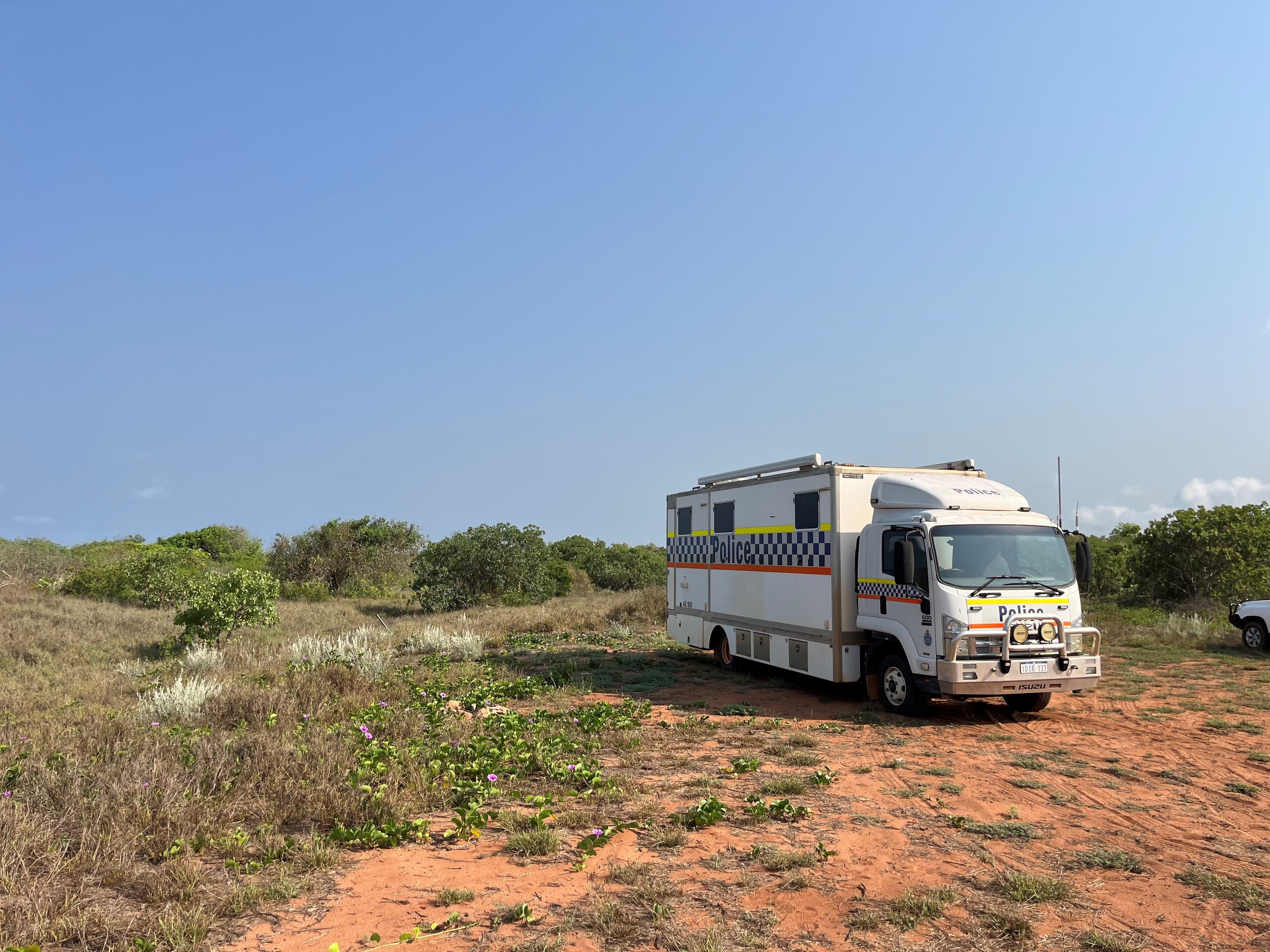 A police truck parked on a dirt track