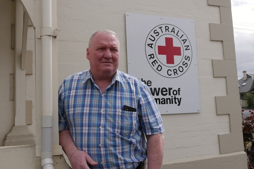 A man stands in front of Red Cross building
