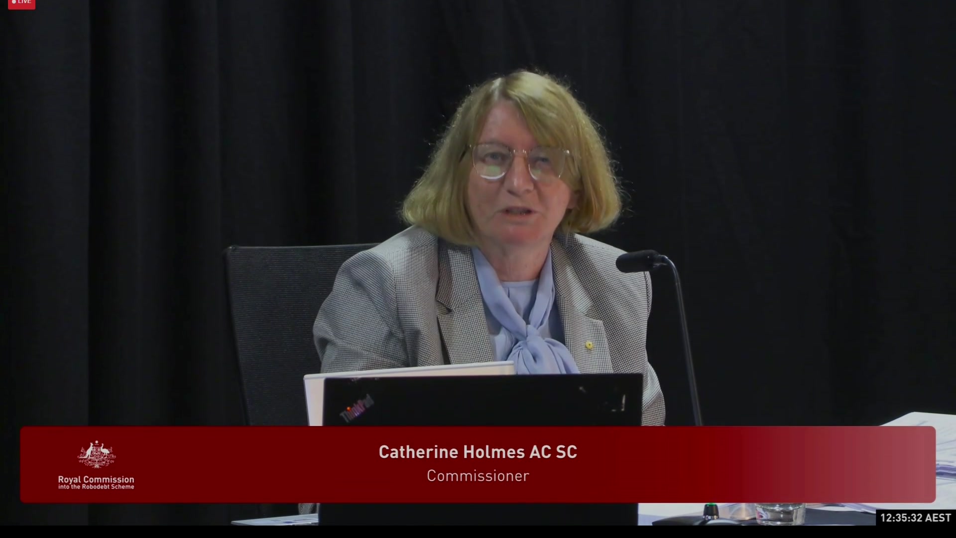 Catherine Holmes speaking into a microphone. 