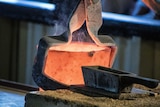 A gold pour with a red hot furnace