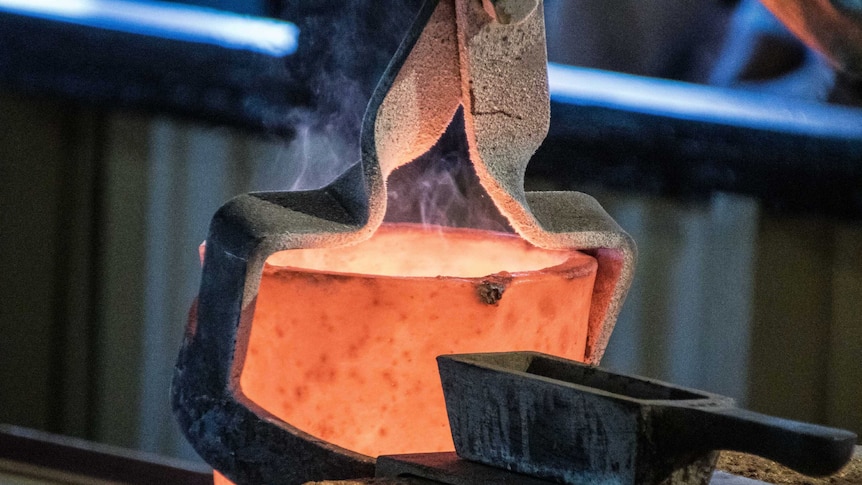 A gold pour with a red hot furnace