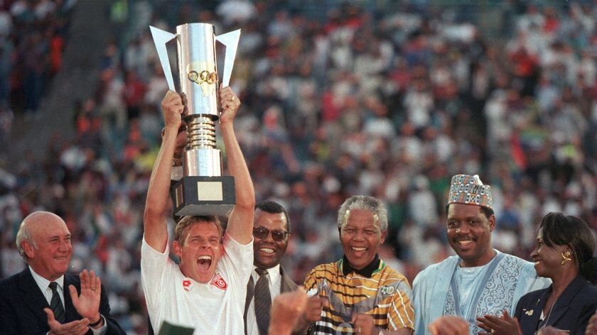 South African captain Neil Tovey holds the African Cup of Nations trophy aloft after being presented it by President Nelson Mandela.