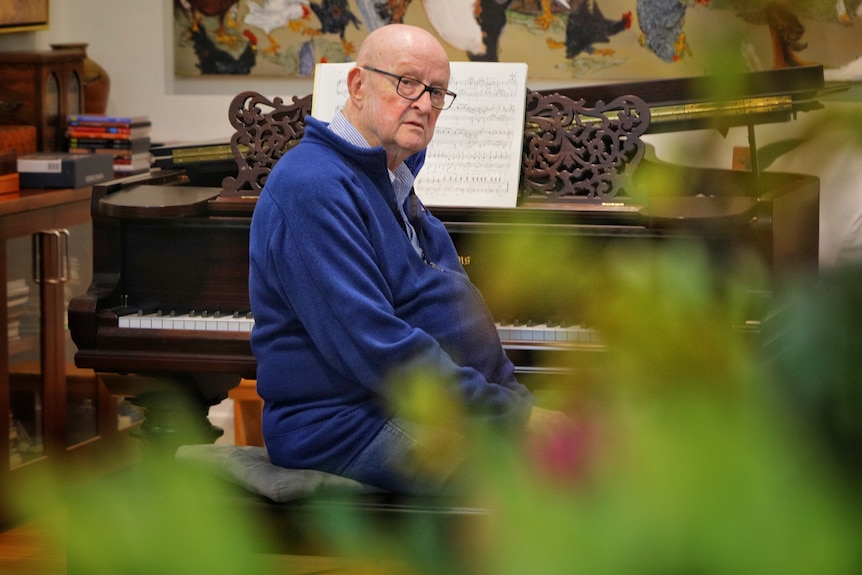 An edlerley man sitting at a piano