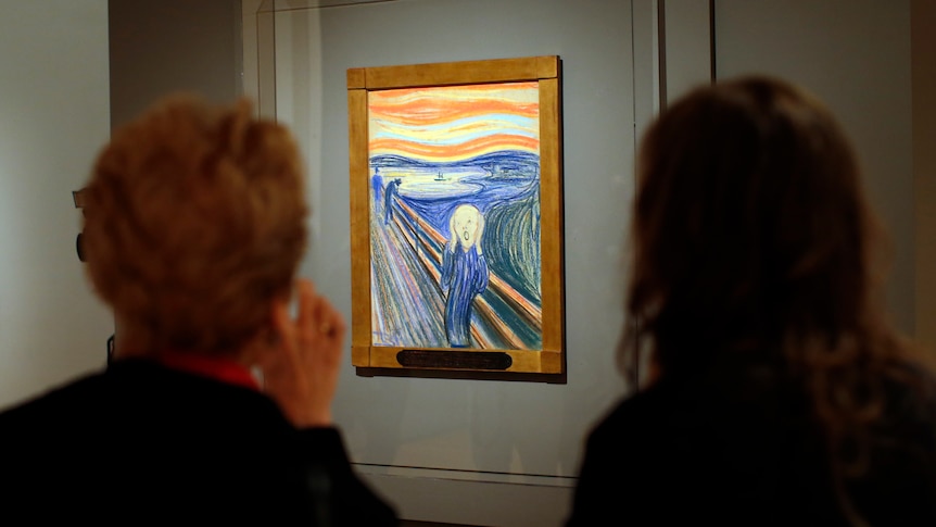 A pastel drawing hangs on a wall as observers look on.