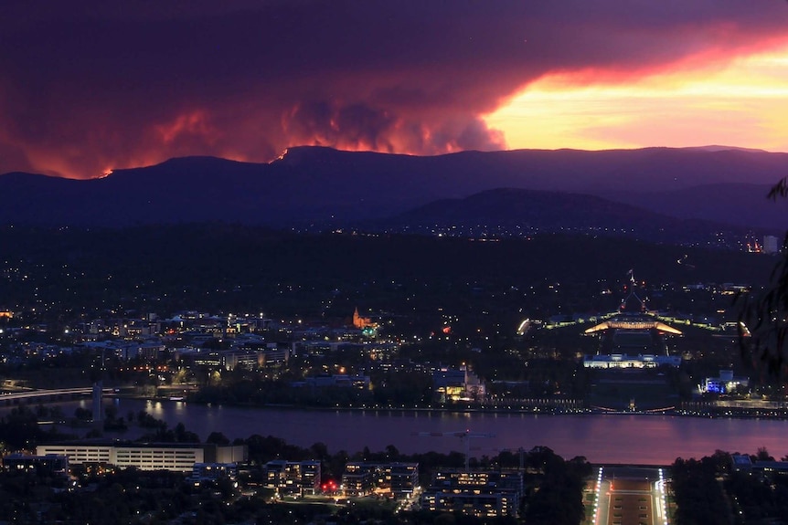 The red of the fire and smoke can be seen from the mountains, Canberra in the foreground.