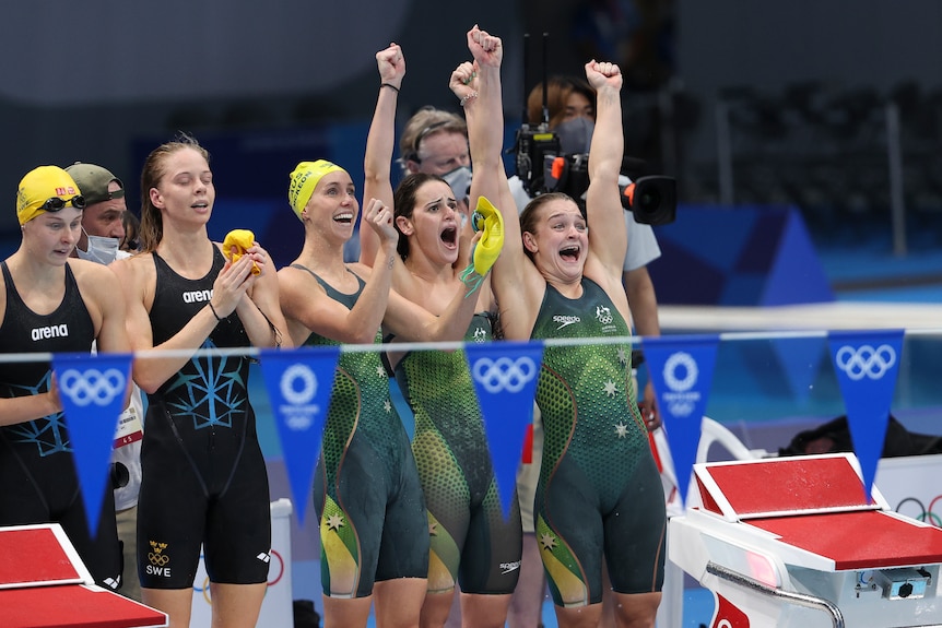 a group of swimmers cheer on their teammates from the side of the pool waving their hands in the air. Ausnew Home Care, NDIS registered provider, My Aged Care
