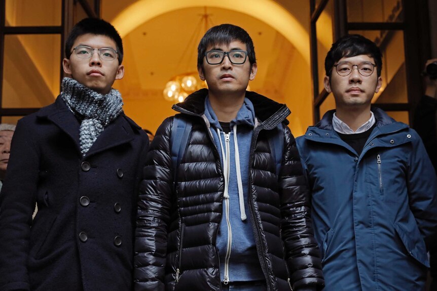 Pro-democracy activists, from left, Joshua Wong, Alex Chow and Nathan Law, walk out from the Court of Final Appeal in Hong Kong