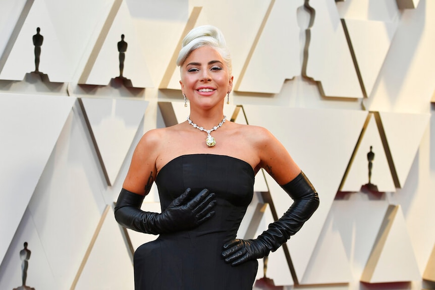 Singer and actress Lady Gaga wearing a black gown, a large diamond necklace and elbow-length gloves