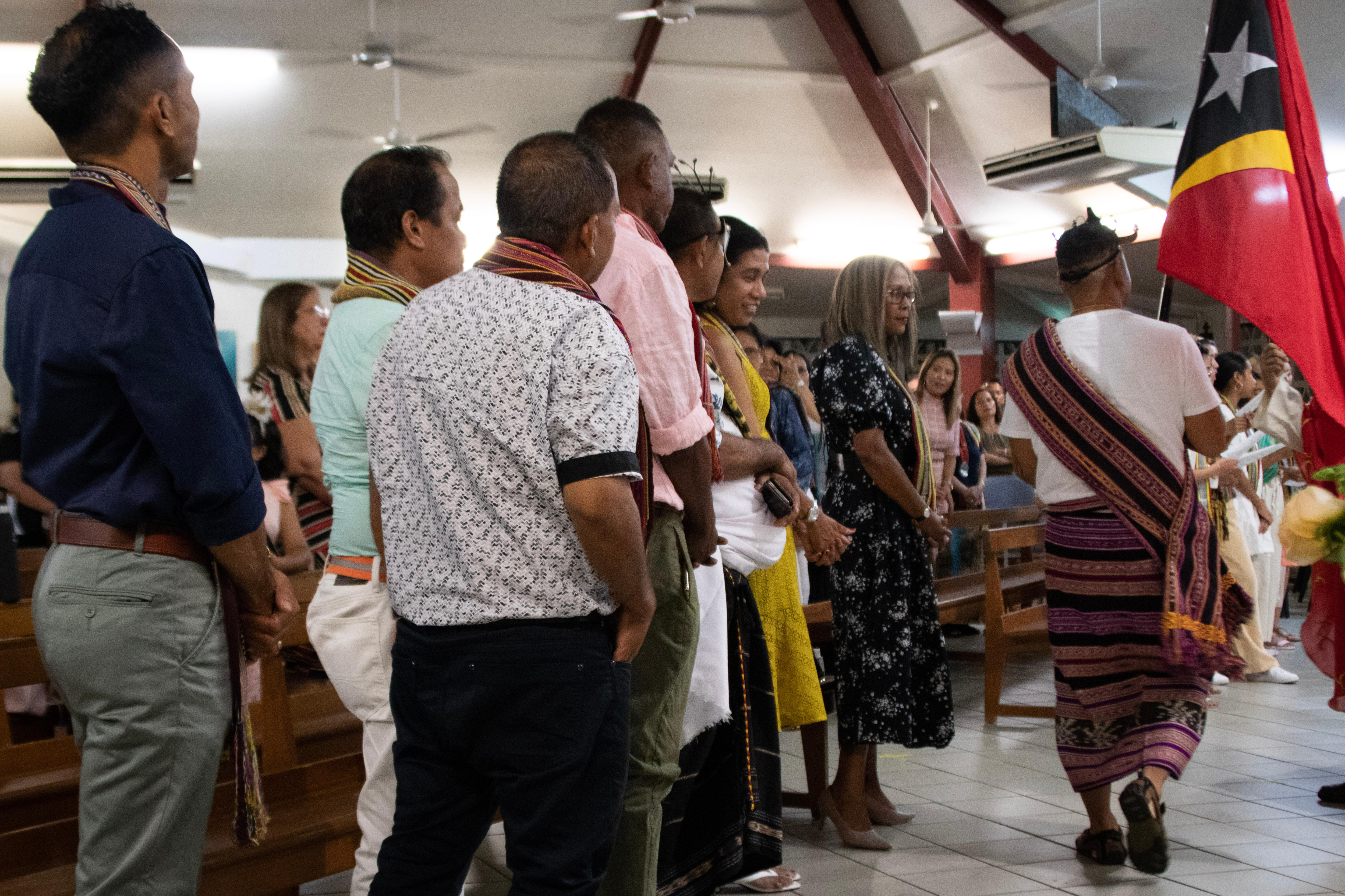 A group of Santa Cruz massacre survivors leaving a church with a flag.