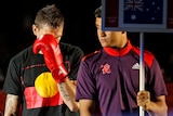 Damien Hooper walks to the ring wearing a T-shirt bearing the Aboriginal flag.