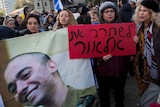 Supporters of Israeli soldier Elor Azaria hold up a photo and signs.