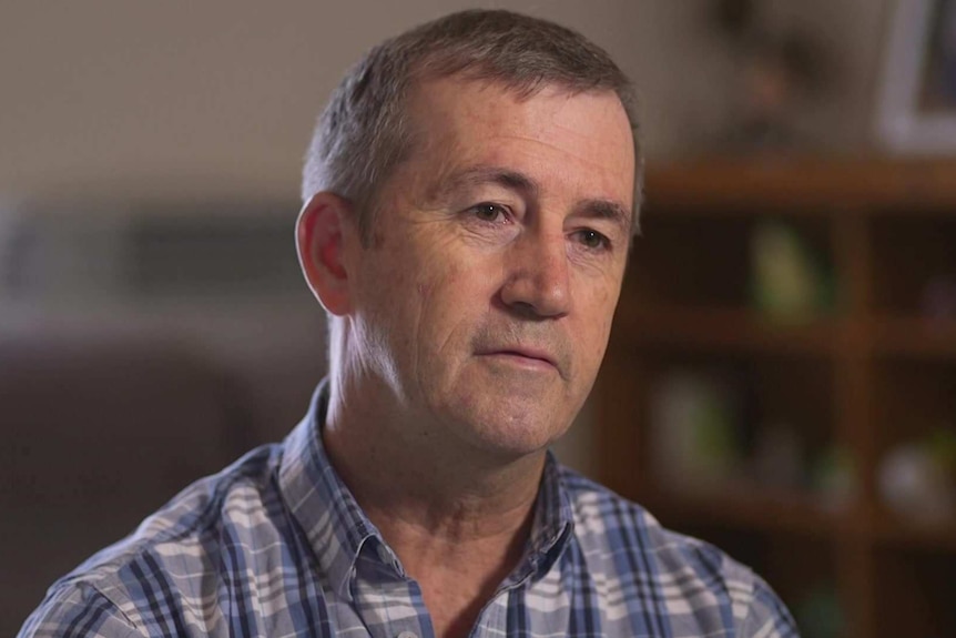 MCU of Stephen Howarth in blue and white check collared shirt