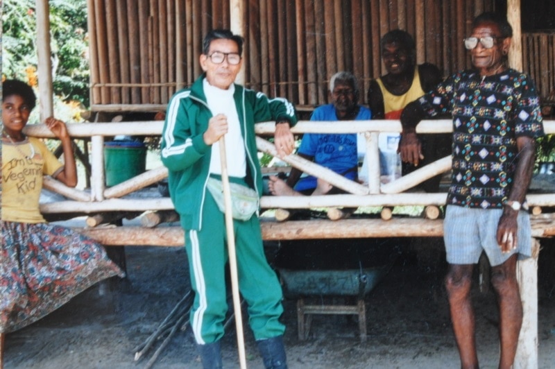 An old photo of Kokichi Nishimura with PNG villagers