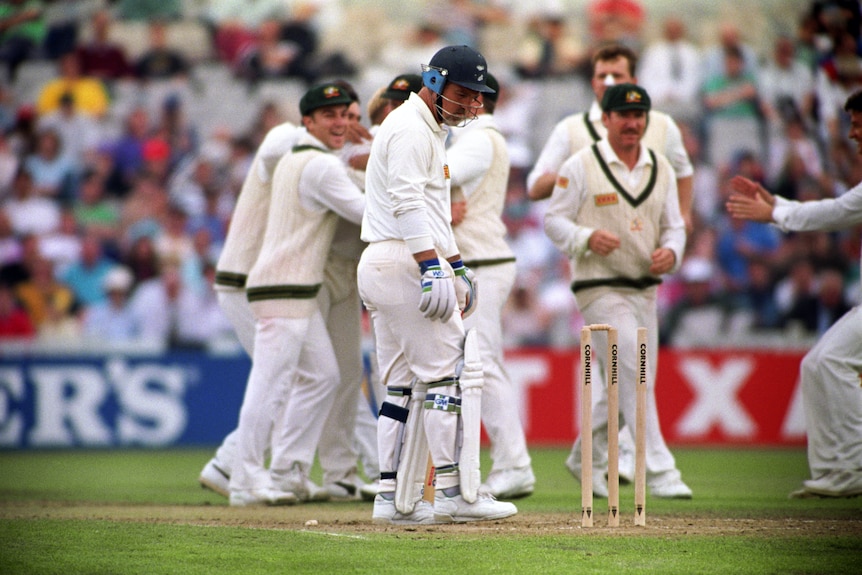 Mike Gatting looks despondently at his stumps as Australians celebrate Shane Warne's ball of the century