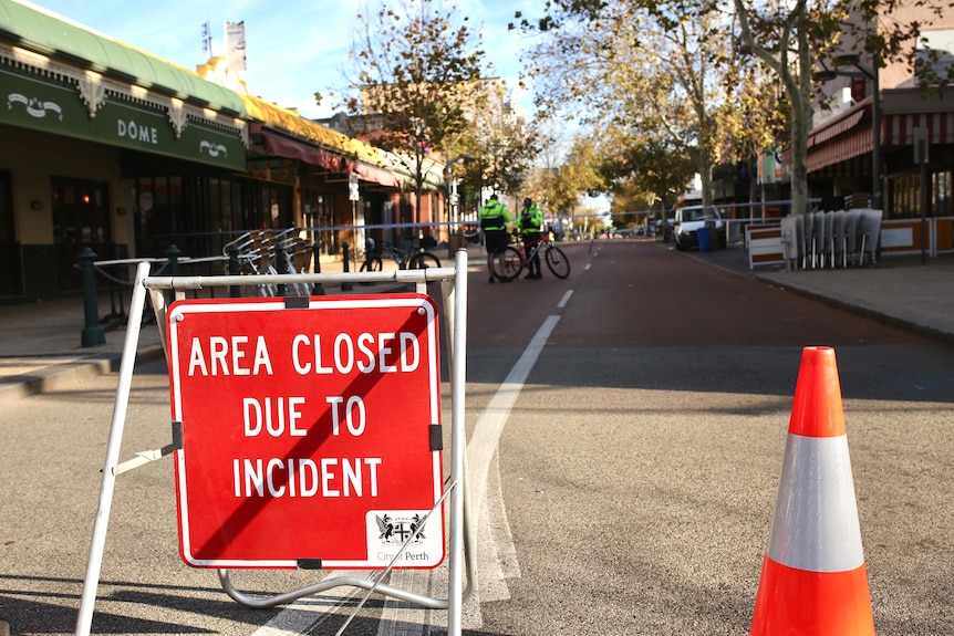 A sign on a streets says Area Closed Due To Incident
