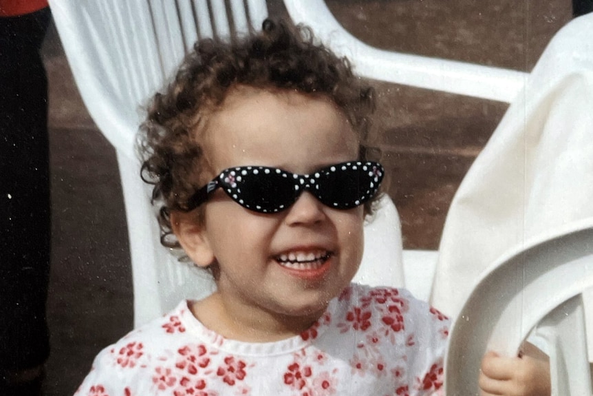 A small girl in black and white polka dot sunglasses 