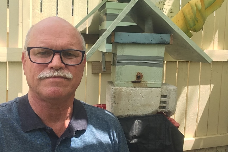 A picture of Phil Baskerville with his backyard beehive.