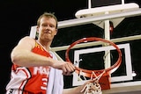 Mat Campbell cuts down the net while standing on a ladder during his playing days for the Hawks.