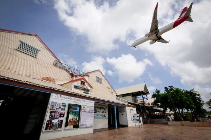 A Qantas plane flies over an outback town.