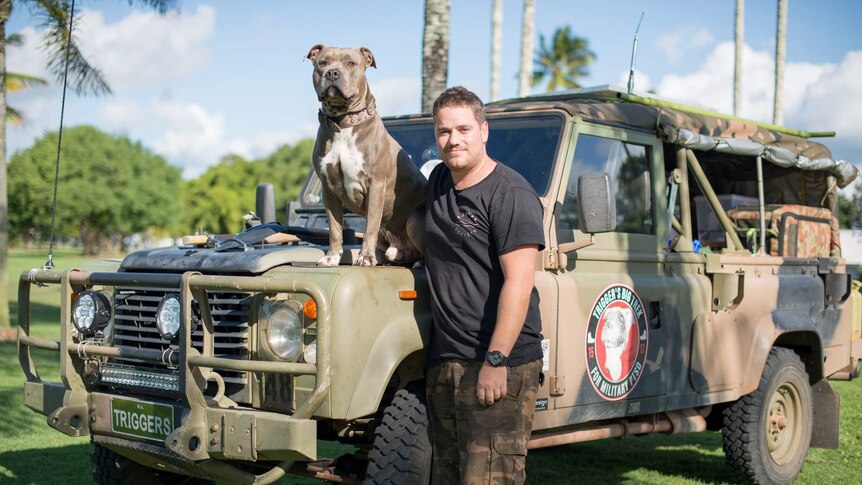 Royce Hardman stands next to his converted four-wheel-drive while his dog, Trigger, sits on the bonnet.