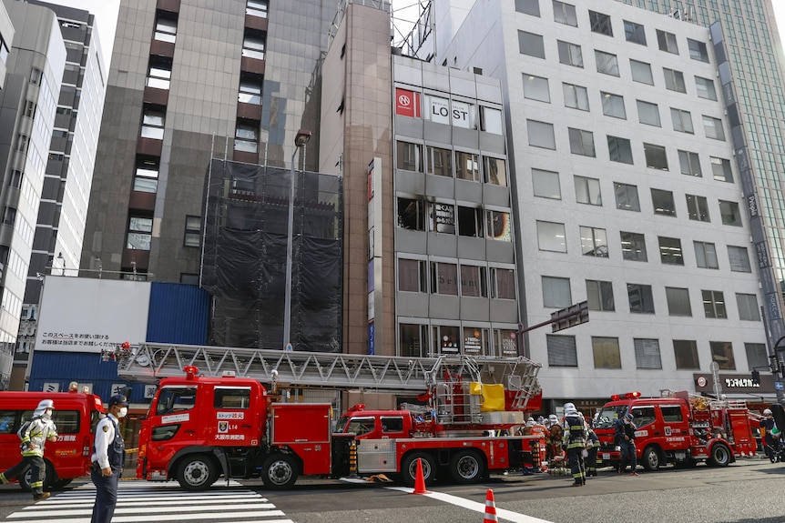 一座城市建筑的外部，外面有消防员。 