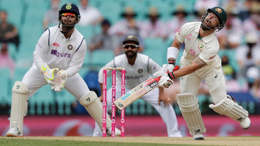 Matthew Wade, holding a bat and stumbling, looks up in the air next to Rishabh Pant.